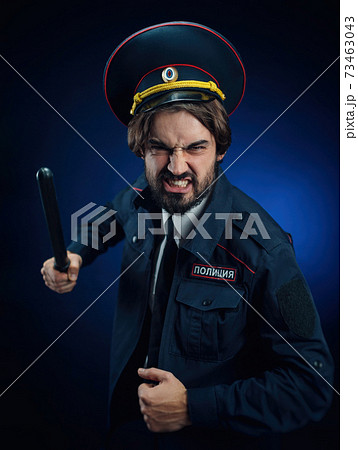 a man in a Russian police uniform with a baton. English translation of " Police" a man in a Russian police uniform with a baton. English translation of " Police" 73463043