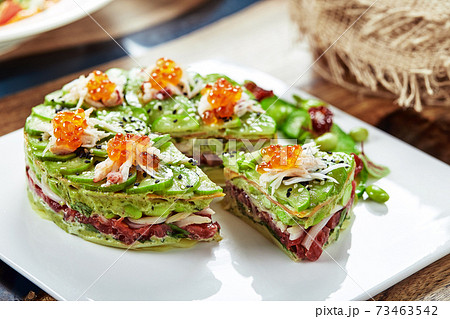 Salad of avokado, seafood, meat, vegetables and pumpkin seeds. Dietary, wholesome and tasty. Banquet festive dishes. Gourmet restaurant menu. White background. 73463542