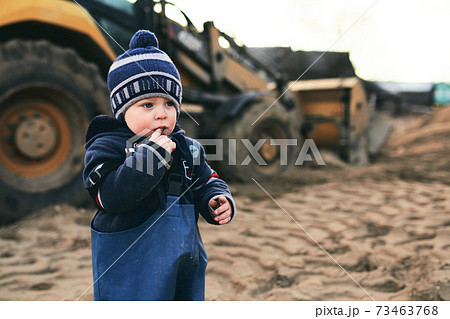 A little boy that is standing in the sand 73463768