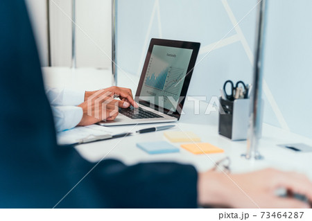 businessman works using a laptop to analyze financial data . 73464287