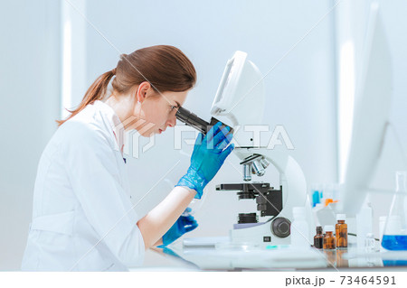close up. female scientist using a microscope in the lab. 73464591
