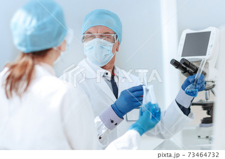 scientific colleagues discuss sitting at the laboratory table. scientific colleagues discuss sitting at the laboratory table. 73464732