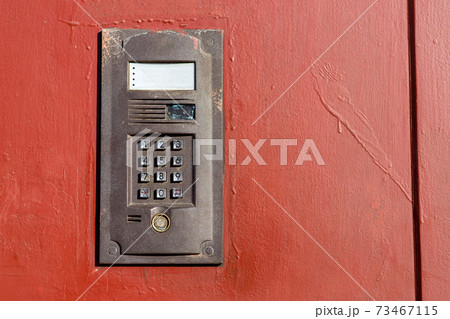 an intercom on metall used door with a keypad for calling close up with copy space. an intercom on metall used door with a keypad for calling close up with copy space. 73467115