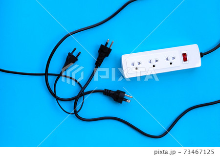Electrical power strip and plug on blue background. Top view Electrical power strip and plug on blue background. Top view 73467125
