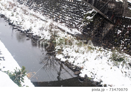 日本の冬の雪と松の木のある町の川	 73470070