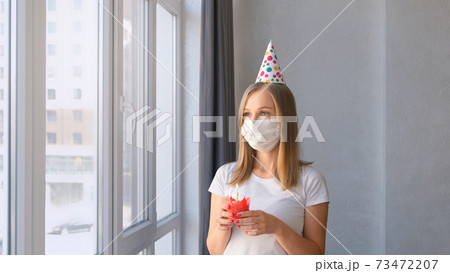 Woman celebrates a birthday at quarantine in home. Woman celebrates a birthday at quarantine in home. 73472207