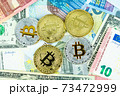 Silver and gold bitcoin coins on paper euro and dollar banknotes. Modern virtual currency 73472999