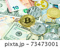 Various cryptocurrency coins on paper dollar and euro banknotes. Bitcoin, ethereum, litecoin and others modern virtual currency 73473001