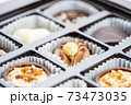 Different chocolate pralines. Box of belgian pralines of different shapes 73473035
