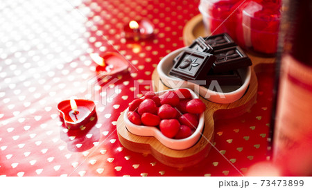 Chocolates and sweets on heart-shaped plates. Festive table setting for date Chocolates and sweets on heart-shaped plates. Festive table setting for date 73473899