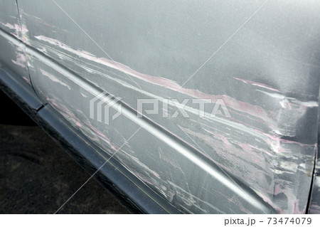 car damage after an accident crash, scratched and crumpled driver's door and fender closeup spoiled surface. car damage after an accident crash, scratched and crumpled driver's door and fender closeup spoiled surface. 73474079