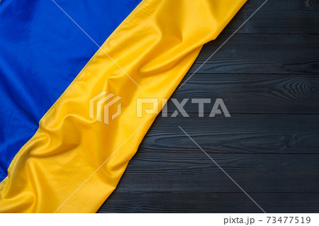 National flag of Ukraine on dark wooden background National flag of Ukraine on dark wooden background 73477519