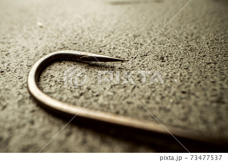 Fishing hooks on concrete textured background macro 73477537