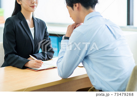 若い男性の悩みを聞くビジネスウーマン 73479268