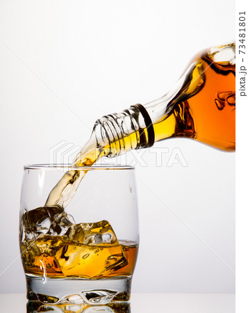 Pouring whisky from a bottle Pouring whisky from a bottle 73481801