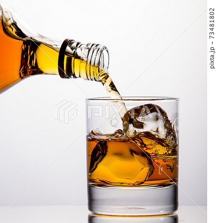 Pouring whisky from a bottle 73481802