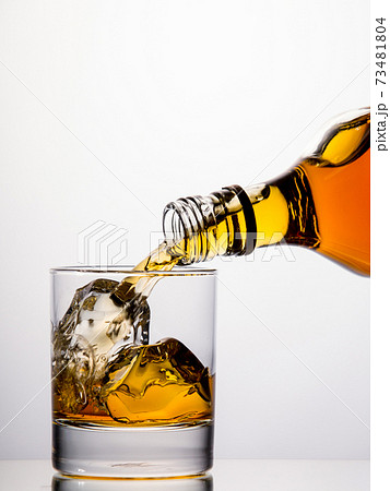 Pouring whisky from a bottle 73481804