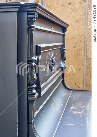 Old-fashioned antique ornamental piano with carved pillars. After restoration 73481939