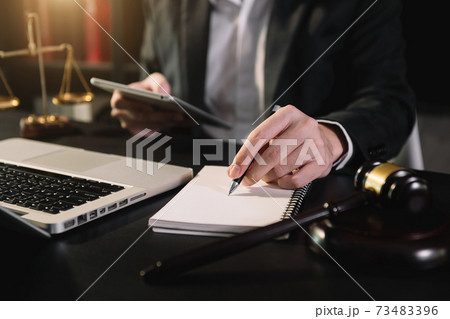 justice and law concept.Male judge in a courtroom  the gavel, working with smart phone and laptop and digital tablet computer 73483396