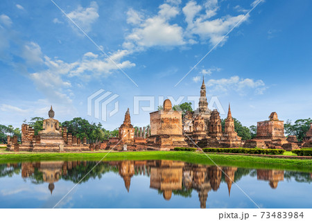 Buddha statue and pagoda Wat Mahathat temple with reflection, Sukhothai Historical Park, Thailand Buddha statue and pagoda Wat Mahathat temple with reflection, Sukhothai Historical Park, Thailand 73483984