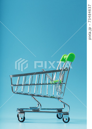 An empty supermarket cart on a blue background. An empty supermarket cart on a blue background. 73484637