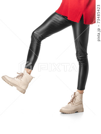 Slender female legs in black leggings and boots isolated on white background 73485423