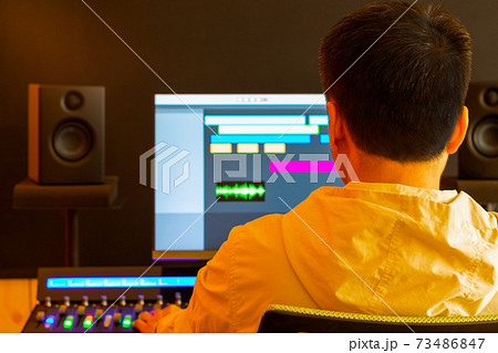 back of asian professional male producer, sound engineer mixing sound on control surface mixer for recording or live broadcasting in studio. post production, recording, broadcasting concept back of asian professional male producer, sound engineer mixing sound on control surface mixer for recording or live broadcasting in studio. post production, recording, broadcasting concept 73486847