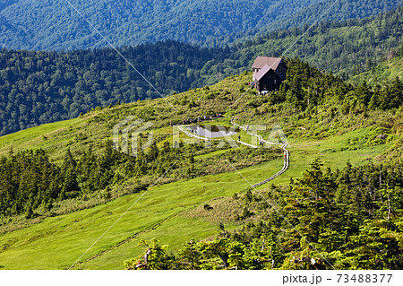 会津駒ヶ岳山頂から見る駒の小屋と駒の池 73488377