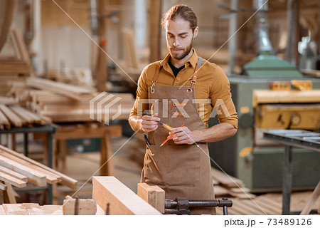Portrait of a handsome carpenter at the joiner's shop 73489126