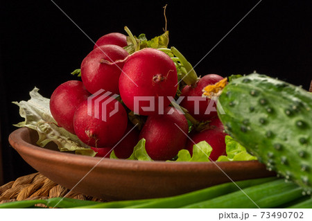 Still life with vegetables on a black background. 73490702