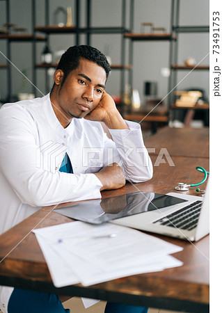 Stressed African American black man doctor looking at laptop reading bad news online 73491753