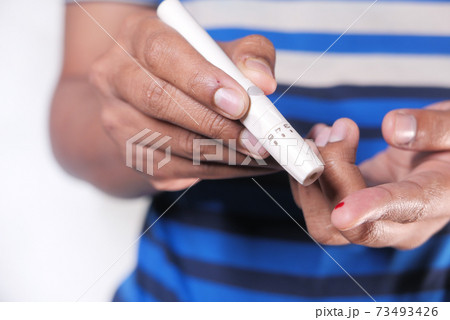 young man's hand measure glucose level isolated on white  73493426