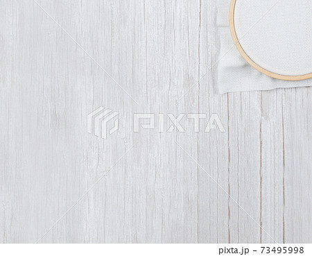 Cross stitch hoop with stretched canvas on wooden background,copyspace Cross stitch hoop with stretched canvas on wooden background,copyspace 73495998