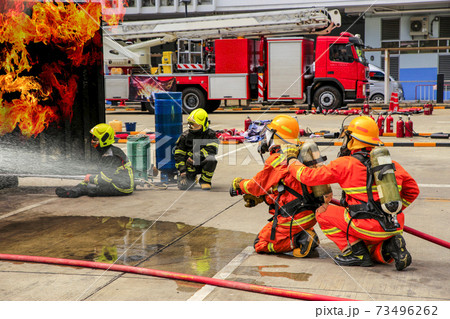 Brave Firefighter Using Extinguisher And Water の写真素材