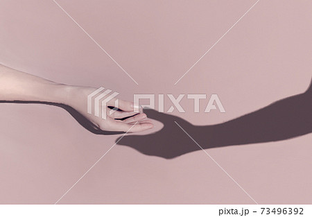 Romantic concept. A woman's hand reaches out towards the shadow of a man's hand which pulls towards 73496392