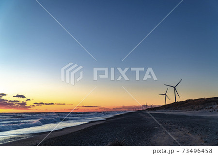 静岡県御前崎市の浜岡砂丘・海沿い浜辺の日没時の風力発電機群 73496458