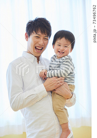 赤ちゃんと写真撮影をするお父さん　子供　家族　記念 73496762