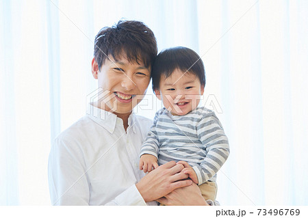 赤ちゃんと写真撮影をするお父さん 子供 家族 記念 赤ちゃんと写真撮影をするお父さん 子供 家族 記念 73496769