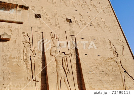 The relief of the entrance of Temple of Horus, Sky God, depicted as a falcon-headed man. Edfu, West bank of the Nile, Aswan Egypt.  73499112