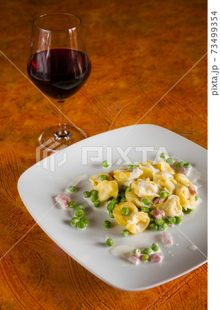 Tortellini with cream ham peas and red wine Tortellini with cream ham peas and red wine 73499354