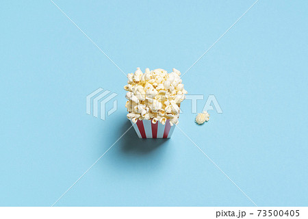 Eating popcorn stop motion video. Popcorn box top view on a blue background. Eating popcorn stop motion video. Popcorn box top view on a blue background. 73500405
