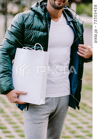 man holding White paper bag and white t-shirt mockup 73503438