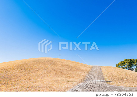 冬晴れの空と丘、つづく道 73504553