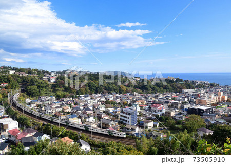相模湾と湯河原の街並みとカーブを通過する185系特急踊り子号 73505910