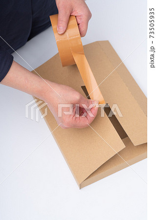 梱包作業をする女性の手元 73505935
