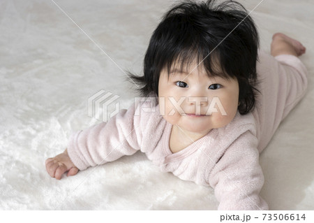 うつ伏せから頭を上げた笑顔の赤ちゃん（0歳、生後6か月、女の子、日本人） 73506614