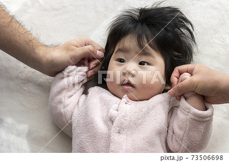 両親と手をつなぐ赤ちゃん 0歳 生後6カ月 日本人 女の子 の写真素材