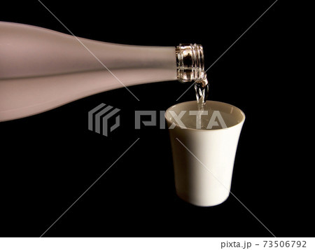白の陶器の猪口に注がれる日本酒 白の陶器の猪口に注がれる日本酒 73506792