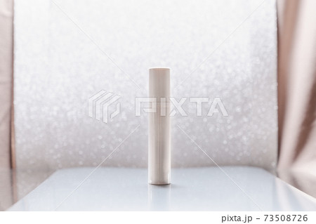 White cosmetic tube on silver glitter background White cosmetic tube on silver glitter background 73508726