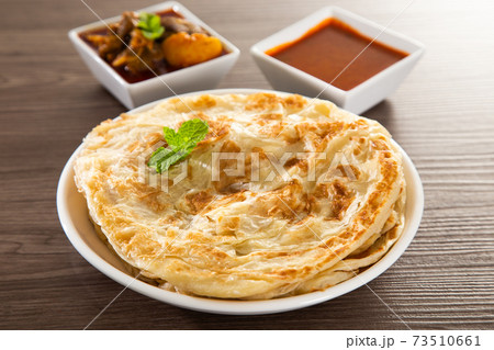 Roti Parata or Roti canai with lamb curry sauce. 73510661